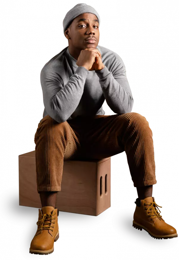 black men fashion model wearing a cap sitting and posing for photo