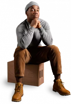 black men fashion model wearing a cap sitting and posing for photo