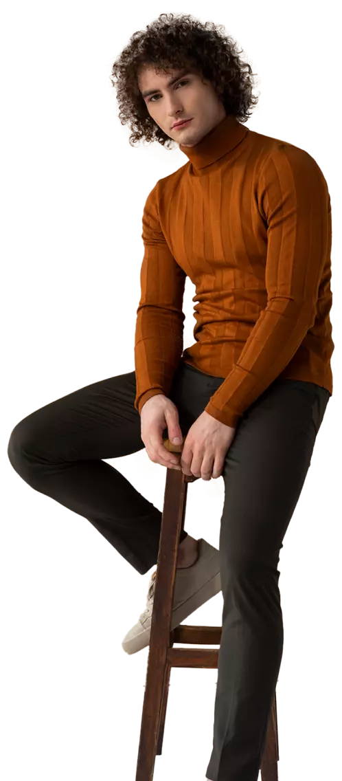 men fashion model with curly hair sitting in chair posing for a photo